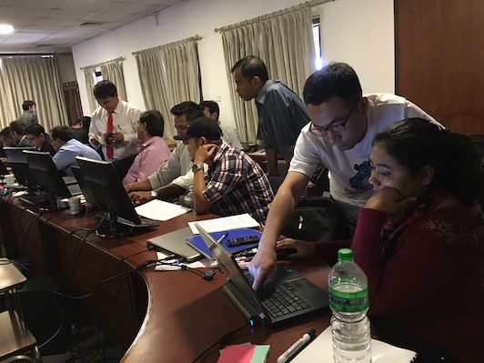 Trainers and trainees working on laptops during hands-on session