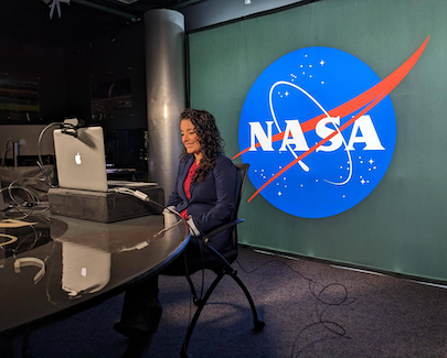 Africa Flores on NASA TV set, seated in front of monitor